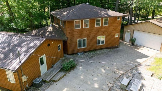 view of front of home featuring an outdoor structure, a garage, and central air condition unit