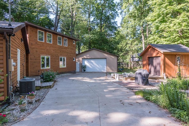 exterior space featuring a garage, central AC unit, and an outdoor structure