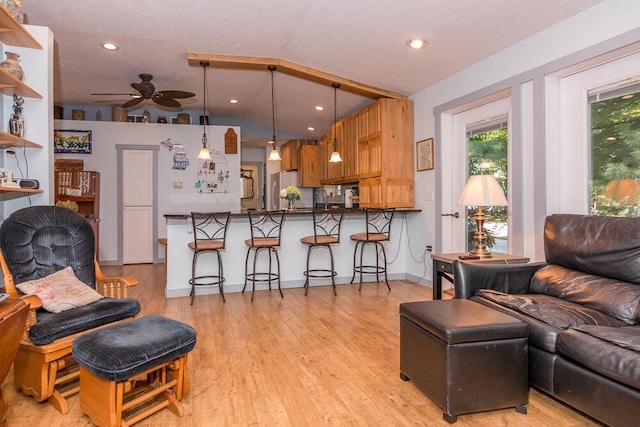 living room featuring light wood-type flooring, vaulted ceiling, and ceiling fan