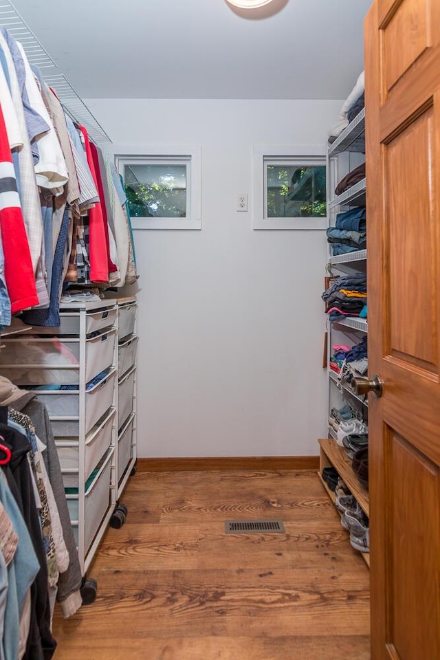 walk in closet with hardwood / wood-style flooring