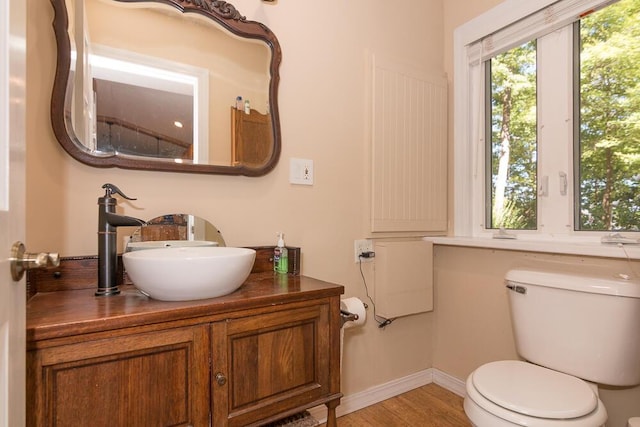 bathroom with hardwood / wood-style flooring, vanity, and toilet