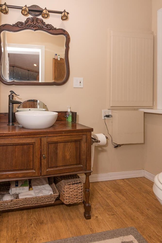 bathroom with vanity, wood-type flooring, and toilet