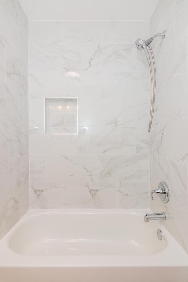 bathroom featuring tiled shower / bath