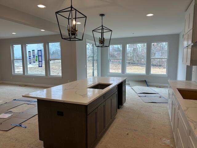 kitchen featuring open floor plan, a healthy amount of sunlight, and light stone countertops