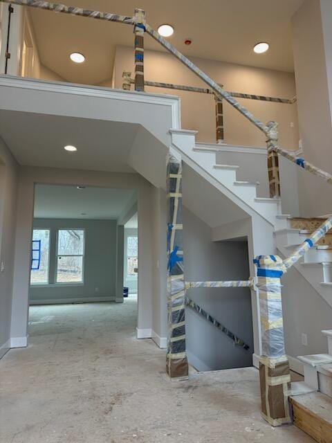 stairway featuring baseboards and recessed lighting