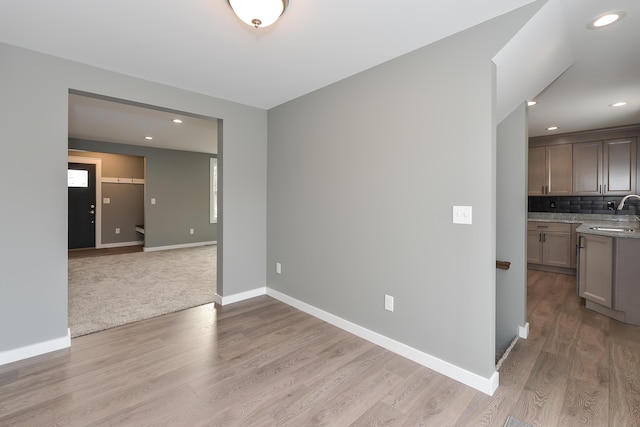 spare room with light hardwood / wood-style floors and sink