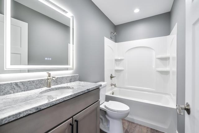 full bathroom featuring hardwood / wood-style flooring, vanity, toilet, and bathing tub / shower combination