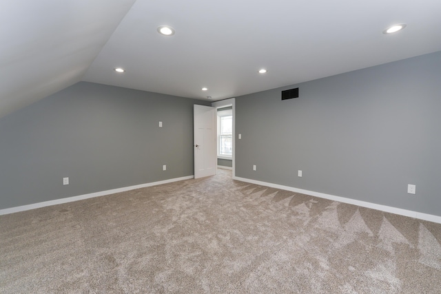 interior space with light carpet and vaulted ceiling