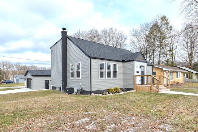 view of home's exterior featuring central AC, a yard, an outbuilding, and a garage