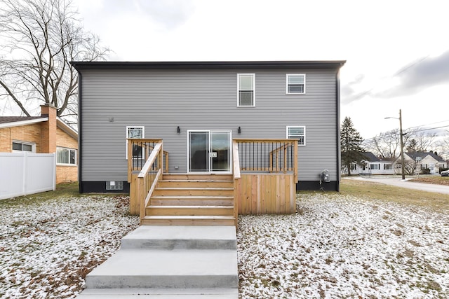 snow covered rear of property featuring a deck