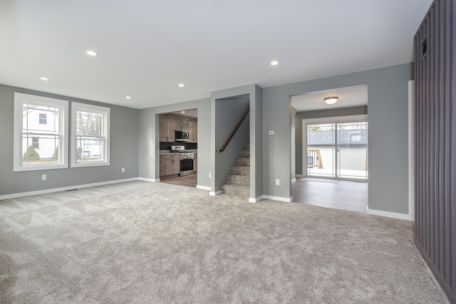 unfurnished living room featuring light colored carpet