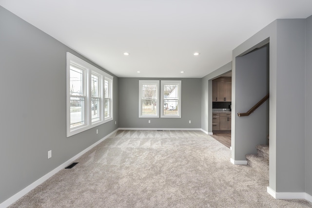 unfurnished living room featuring light carpet