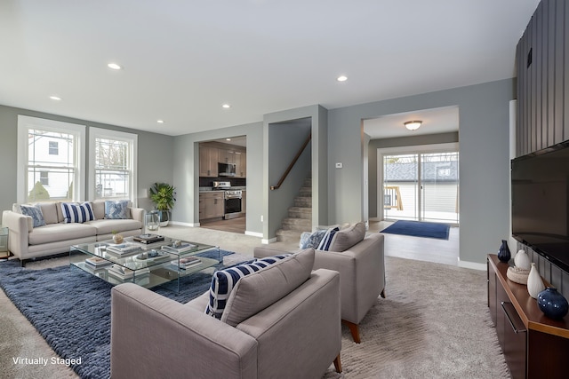 living room with baseboards, stairway, light colored carpet, and recessed lighting