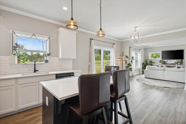 kitchen with white cabinetry, hanging light fixtures, and sink