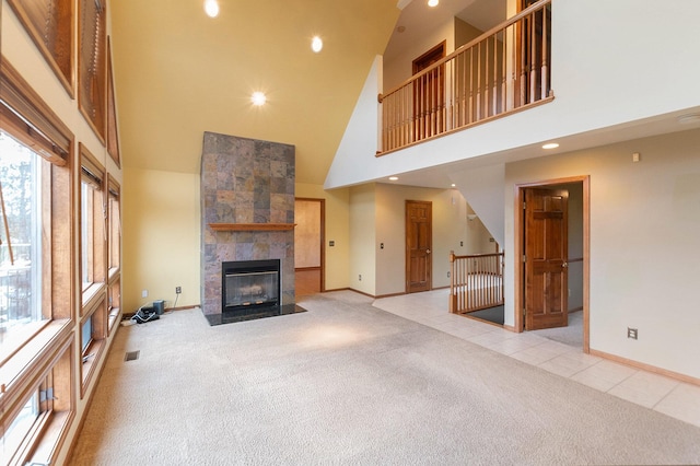 unfurnished living room with a fireplace, a high ceiling, and light colored carpet