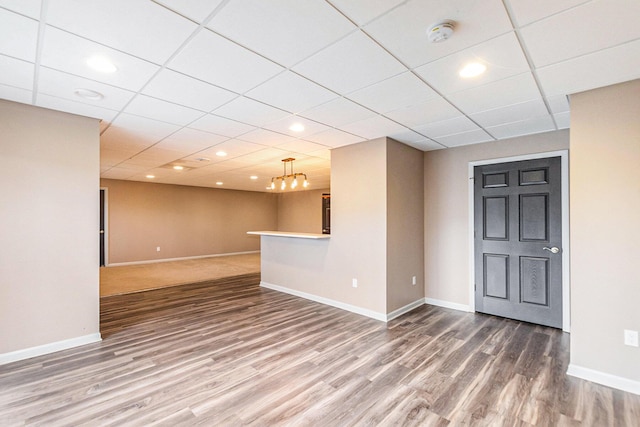 unfurnished living room featuring a chandelier and hardwood / wood-style floors