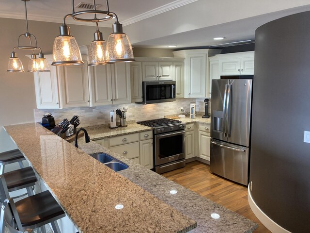 kitchen featuring stainless steel appliances, kitchen peninsula, pendant lighting, decorative backsplash, and a breakfast bar