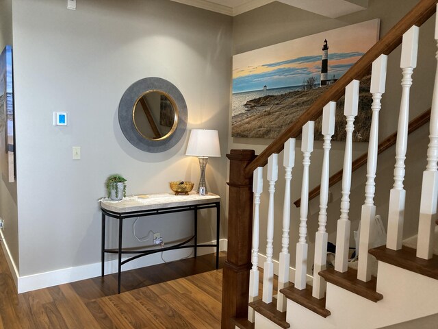 stairway with crown molding and hardwood / wood-style floors