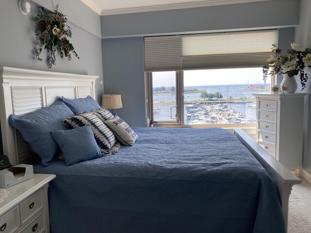 bedroom with carpet flooring, a water view, and ornamental molding