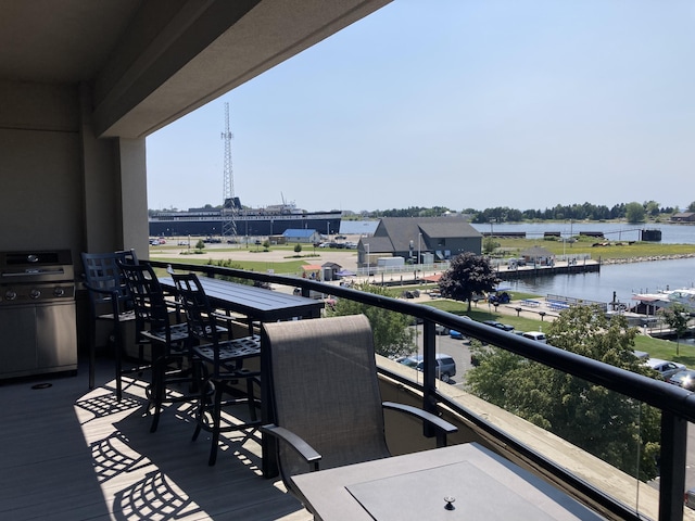 deck with area for grilling and a water view