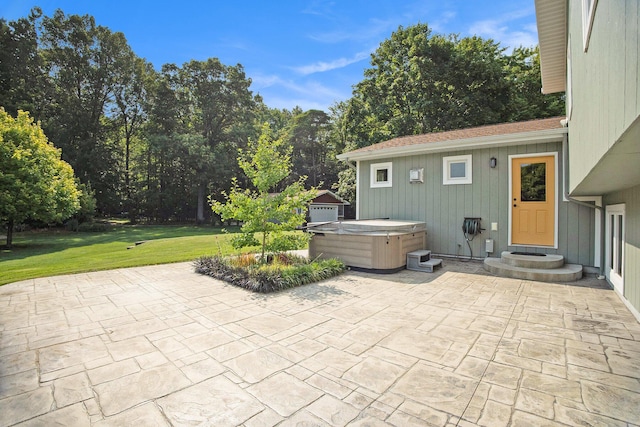 view of patio / terrace featuring a hot tub, a garage, and an outbuilding