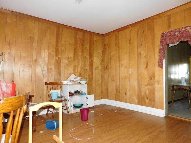 living area with hardwood / wood-style flooring and wooden walls