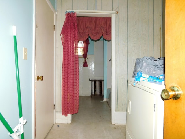 hallway featuring washer / clothes dryer and wood walls