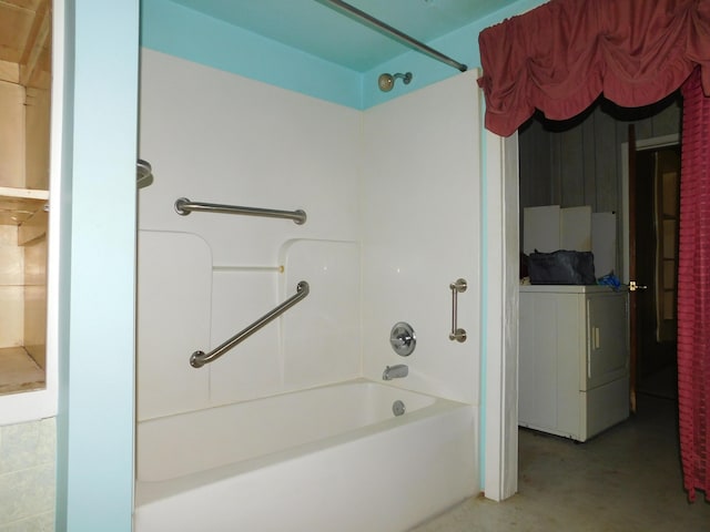 bathroom with concrete floors, bathtub / shower combination, and washer / dryer