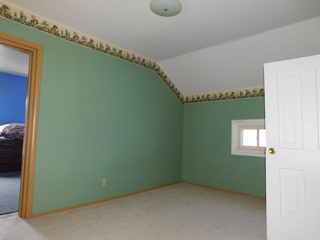 additional living space featuring light carpet and lofted ceiling