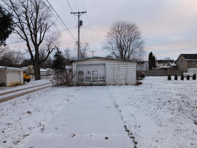 yard covered in snow featuring a garage and an outdoor structure