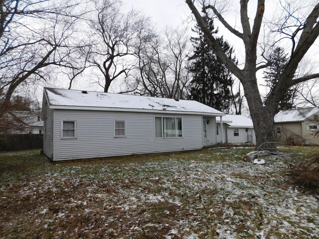 view of snow covered back of property