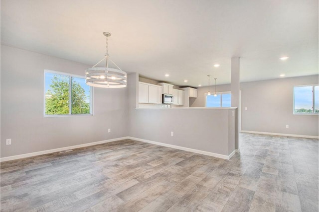 empty room featuring light hardwood / wood-style floors and an inviting chandelier