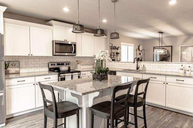 kitchen with white cabinets, pendant lighting, sink, and appliances with stainless steel finishes