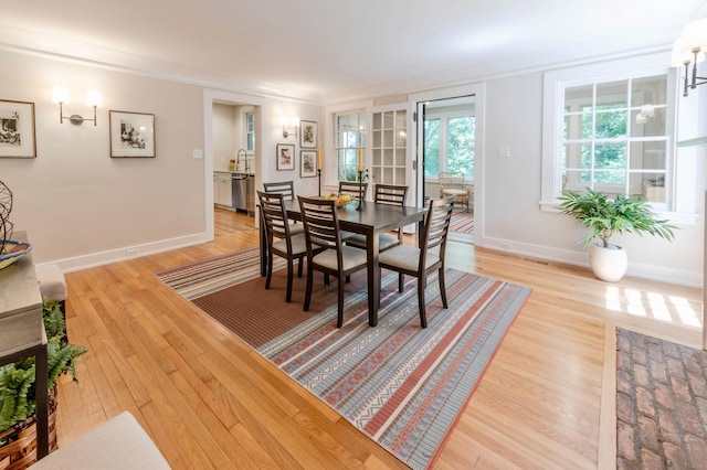 dining space with hardwood / wood-style floors and ornamental molding