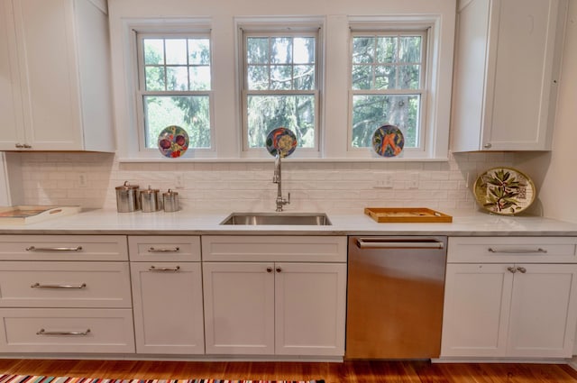 kitchen featuring light stone countertops, tasteful backsplash, sink, dishwasher, and white cabinetry