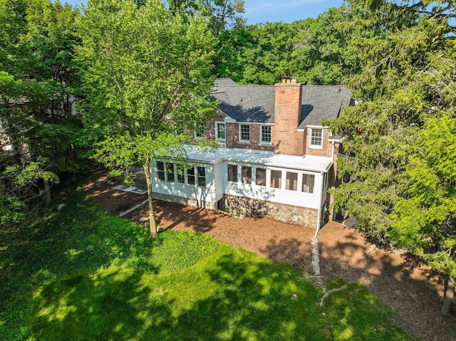 rear view of house with a sunroom and a yard