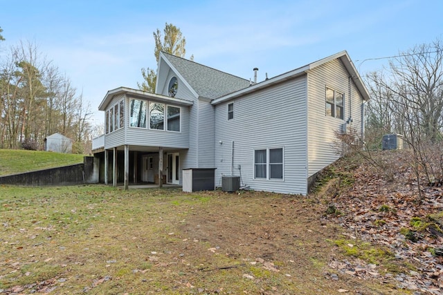 back of house with a lawn, a sunroom, and central AC unit