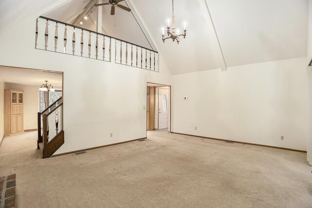 unfurnished living room with carpet, ceiling fan with notable chandelier, beamed ceiling, and high vaulted ceiling