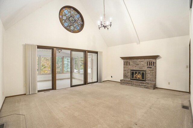 unfurnished living room featuring light carpet, high vaulted ceiling, a notable chandelier, and a brick fireplace