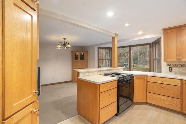 kitchen featuring tasteful backsplash, black electric range, light hardwood / wood-style flooring, a notable chandelier, and kitchen peninsula