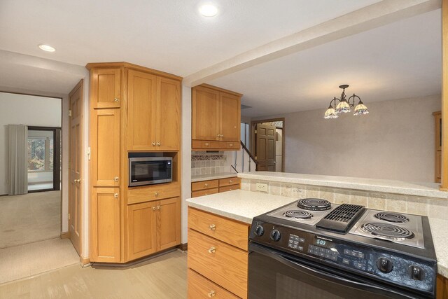 kitchen with backsplash, hanging light fixtures, light hardwood / wood-style flooring, black range with electric cooktop, and a notable chandelier