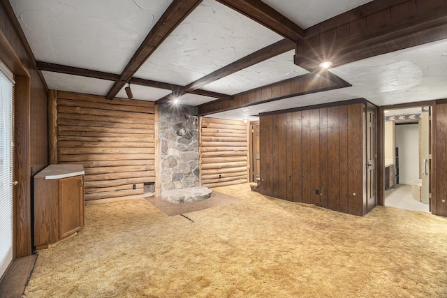 unfurnished living room featuring wooden walls, beam ceiling, light colored carpet, and log walls