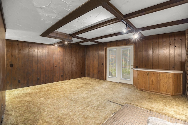 interior space featuring carpet, beam ceiling, and wooden walls