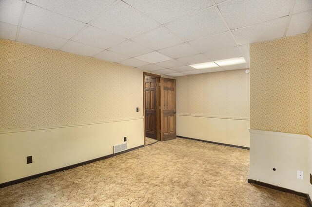 carpeted spare room featuring a paneled ceiling