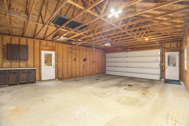 garage with wood walls and a garage door opener