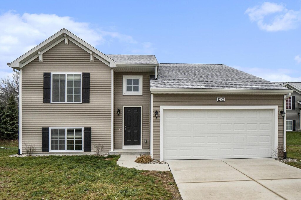 view of front of house with a garage and a front lawn