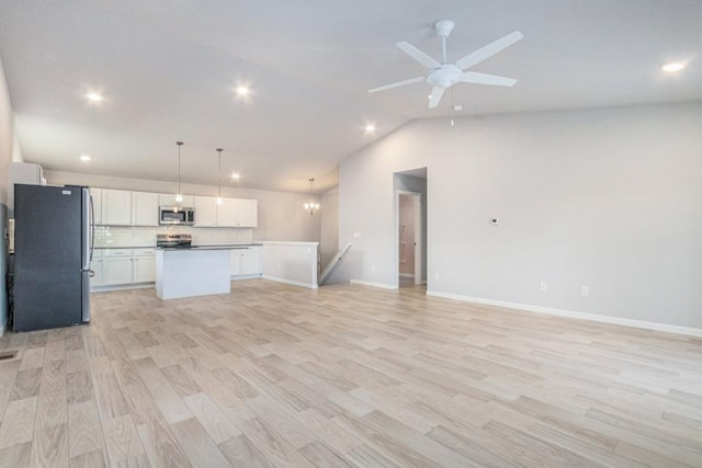 kitchen featuring light wood-type flooring, a kitchen island, pendant lighting, stainless steel appliances, and white cabinets