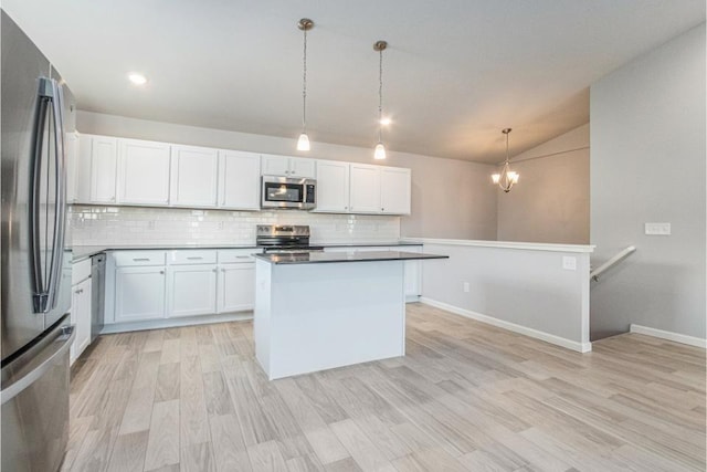 kitchen with hanging light fixtures, a kitchen island, appliances with stainless steel finishes, and white cabinets