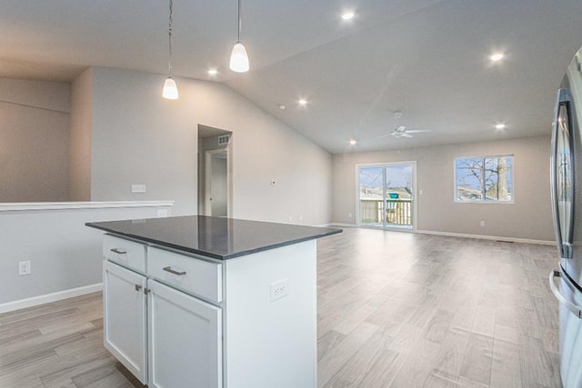 kitchen featuring a kitchen island, stainless steel refrigerator, decorative light fixtures, white cabinetry, and light hardwood / wood-style flooring