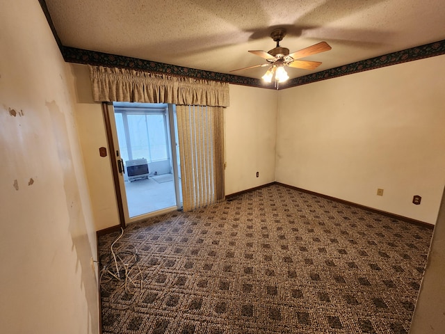 carpeted empty room featuring ceiling fan and a textured ceiling